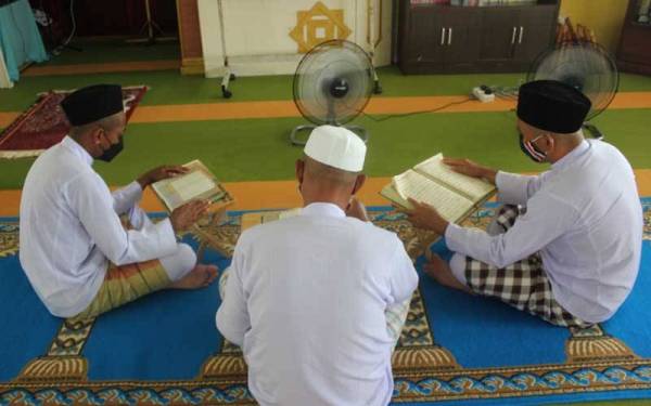 Rafie (kanan) ketika membaca Al-Quran ketika menjalani rawatan pemulihan di Puspen Papar, Kimanis.