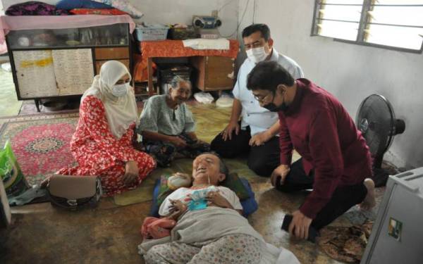 Zahidi (kanan) dan isterinya, Nooraine (kiri) ketika berkunjung ke rumah Munah (dua dari kiri) dan anaknya, Murni untuk menyampaikan zakat dan bantuan di Kampung Medang Gatal, Beseri, Padang Besar pada Selasa. Turut hadir, Ruzaini (dua dari kanan).