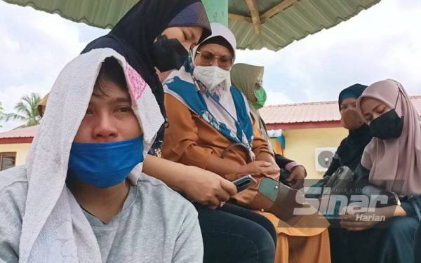 Mohd Fazlan Nizam (depan) dan isteri (tudung hitam) reda dengan pemergian dua anak mereka yang terkorban dalam kebakaran di sebuah rumah kedia di Bandar Seri Iskandar pada Khamis.