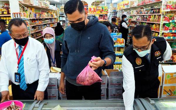 Dr Muhamad Akmal (tengah) memeriksa makanan sejuk beku dalam peti sejuk ketika pemeriksaan sempena Operasi Hari Raya (Op Raya 2022) di sebuah pasar raya hari ini. - Foto Bernama