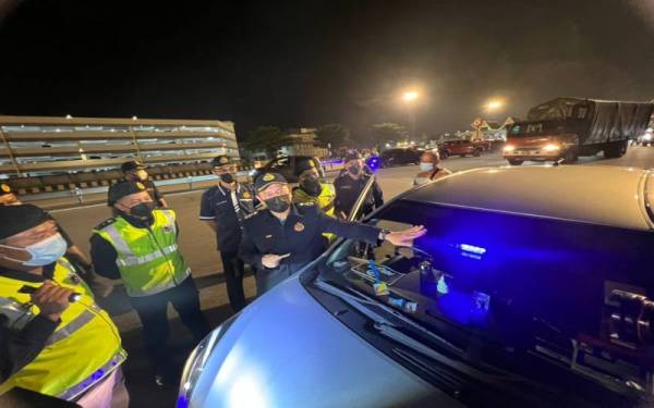 Aedy Fadly (kanan) meninjau Ops Khas Bersepadu di Plaza Tol Juru pada malam Khamis.