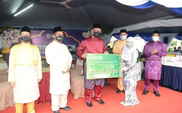 Haim Hilman (tiga kiri) menyerahkan bantuan zakat buat pelajar UUM di Masjid Sultan Badlishah UUM pada petang Khamis. Hadir sama Zakaria (dua dari kiri). - Foto UUM