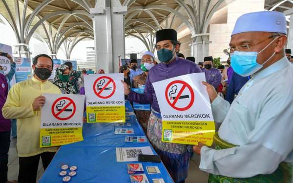 Khairy Jamaluddin bersama Idris (kanan) menunjukkan poster Dilarang Merokok selepas melancarkan Program Perkhidmatan Berhenti Merokok mQuit Masjid di Masjid Tuanku Mizan Zainal Abidin hari ini. Foto Bernama