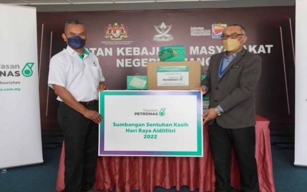 Zulkhairi (kanan) menerima sumbangan daripada Ketua Pegawai Operasi Petronas Pantai Timur, Azeman Said (kiri) pada Majlis Penyerahan Sentuhan Kasih Aidilfitri 2022 Yayasan Petronas di pejabat JKM Pahang.