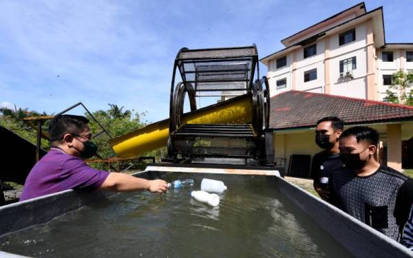 Jidon Adrian membuat demo bagaimana jentera pembersih sungai ciptaan pelajar Falkulti Kejuruteraan UMS berfungsi. - Foto Bernama