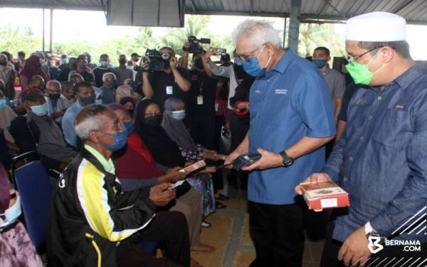 Hamzah menyerahkan sumbangan kepada golongan asnaf sempena Majlis Sumbangan Asnaf Parlimen Larut di Dewan Astaka Batu Kurau, pada Sabtu. - Foto Bernama