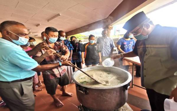 Penduduk berbilang kaum Taman Rasa Sayang bergotong-royong memasak bubur lambuk.