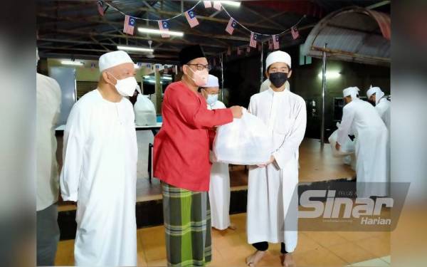 Ahmad Faizal (tengah) menyampaikan makanan sahur kepada pelajar Maahad Tahfiz Al-Quran Wal-Qiraat Addin 7, Jalan Tambun, sempena program Singgah Sahur Bersama Media dan Belia Negeri Perak.