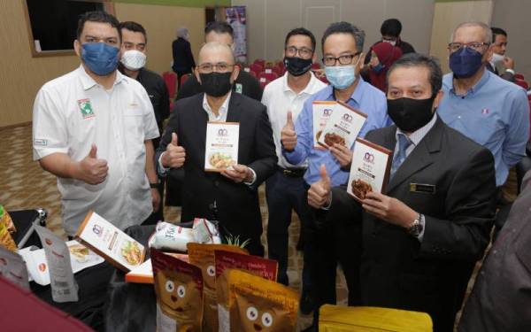 Ronald (dua dari kiri) bersama tetamu yang hadir menunjukkan salah satu produk keluaran tempatan di bawah jenama MyKitchen yang dipamerkan.