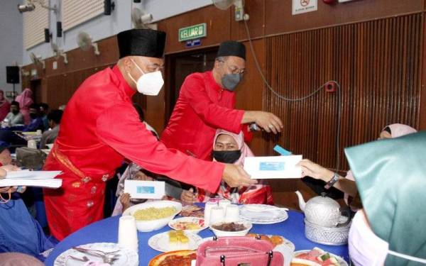 Rahman (kiri) bersama kepimpinan Bahagian Sabak Bernam menyampaikan sumbangan ke penerima bantuan.