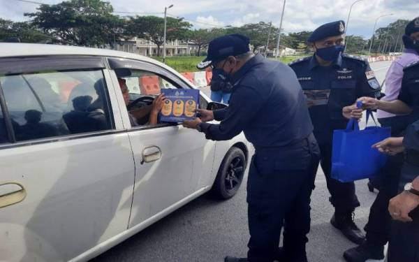 Ramli menyampaikan sumbangan kepada penggunaan jalan raya pada program Pencegahan Ketua Polis Pahang bersama masyarakat daerah Pekan.