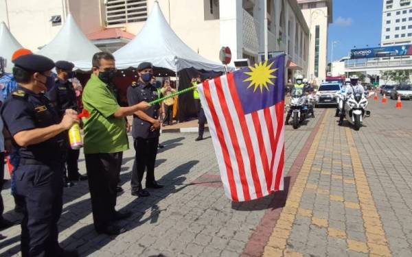 Azman (depan dua dari kiri) membuat pelepasan konvoi bersempena Majlis Pelancaran Kempen Keselamatan Jalan Raya dan Ops Bersepadu Hari Raya Aidilfitri Peringkat Kedah di Lorong Che Det, Alor Setar pada Isnin.