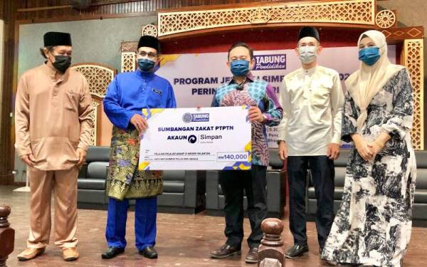 Simbolik penyerahan peruntukan sumbangan zakat Jelajah Simpan SSPN 2022 di Negeri Kelantan berjumlah RM140,000 oleh Wan Saiful (tengah) kepada Zain (dua dari kiri).