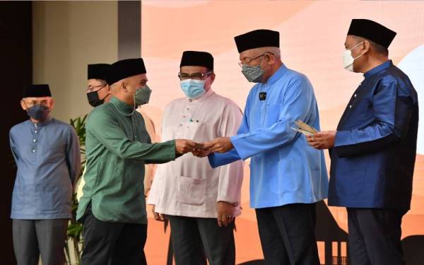 Mahdzir menyampaikan sumbangan kepada warga KPLB semasa hadir Majlis Perhimpunan Bulanan dan Iftar Kementerian Pembangunan Luar Bandar (KPLB) di Putrajaya, pada Selasa. - Foto Bernama 