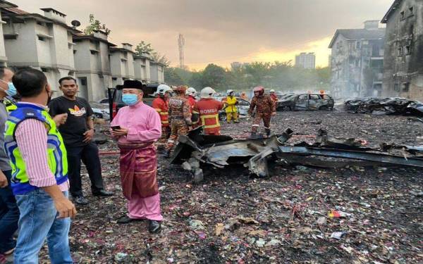 Eng Lai (kanan) hadir melihat sebuah stor penyimpanan barang kes di Sentul yang terbakar pada Selasa.