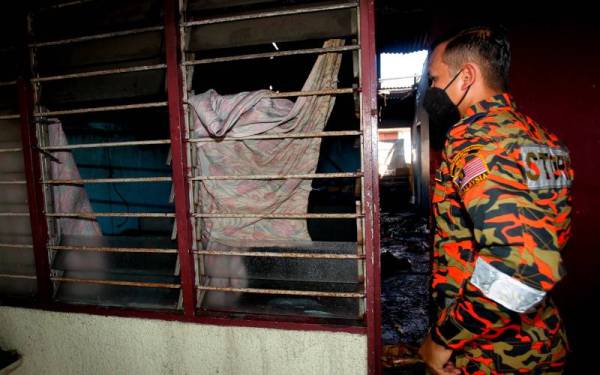 Ketua Balai Bomba Meru Raya Penolong Penguasa Bomba, Sharudi Muhammad Halil (kiri) membuat pemeriksaan di lokasi kebakaran yang membabitkan empat rumah di Hala Taman Meru 10, Taman Meru Fasa 2B pada Rabu. - Foto Bernama