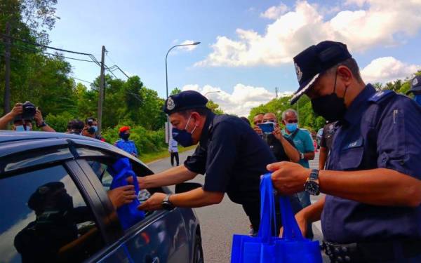 Muhamad Zaki (dua dari kanan) beramah mesra dengan pengguna jalan raya semasa Majlis Pelancaran Op Selamat 18/22 Sempena Hari Raya Aidilfitri di Stesen Penguatkuasa JPJ Bukit Jawa, Pasir Puteh pada Rabu.