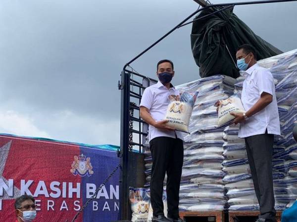 Onn Hafiz (kiri) dan Azmi menunjukkan kampit beras yang akan diedarkan menerusi Bantuan Kasih Bangsa Johor pada program berkenaan pada Rabu.