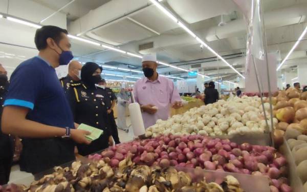 Wan Romani (kanan) ketika Program Walkabout Skim Harga Maksimum Musim Perayaan (SHMMP) Hari Raya Puasa 2022 di TF Value Mart Alor Setar, Alor Setar pada Rabu.