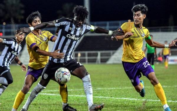 Pemain Terengganu FC II, Jordan Mintah (tengah) diasak pemain UiTM FC, Izaaq Izhan Yuswardi (kanan) pada perlawanan Liga Premier 2022 di Stadium Sultan Ismail Nasiruddin Shah malam tadi. Terengganu FC II menewaskan UiTM FC dengan 2-0. - Foto Bernama