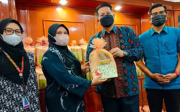 Razli (dua dari kanan) menyerahkan sumbangan bakul hari raya kepada Majidah (dua dari kiri) untuk diagihkan kepada pengamal media yang bernaung di bawah Kemudi di Jabatan Penyiaran Kelantan, Kota Bharu pada Khamis.