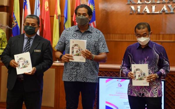 Khairy Jamaluddin (tengah) menunjukkan buku laporan pada Majlis Pelancaran Laporan Skim Peduli Sihat Kesihatan B40 (PeKa B40) tahun 2021 di Dewan Serbaguna Kementerian Kesihatan, pada Khamis. - Foto Bernama