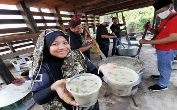 Nur Syafiqah Sabaruddin, 19 menunjukkan bubur lambuk asli Terengganu yang dihasilkan sempena Hari KRT Kg Laut untuk diagih kepada penduduk setempat.