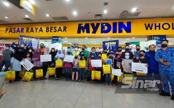 Amirul Syahir (sembilan dari kanan) bersama sebahagian anak yatim dan rakan NGO Kedah yang menjayakan program Tautan Hati Secebis Kasih di Mydin Mall Alor Setar.