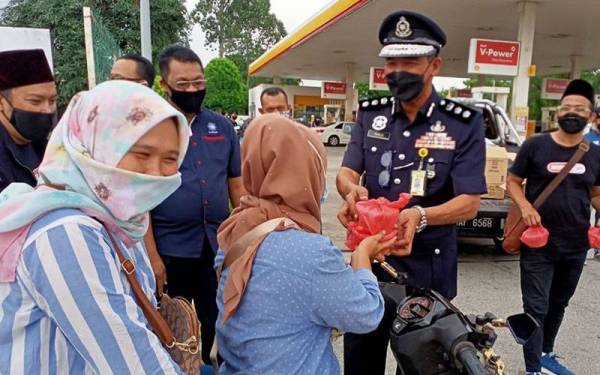 Khalid menyampaikan bubur lambuk kepada orang ramai ketika Program Sentuhan Kasih Ramadan anjuran Pertubuhan Sentuhan Kasih Al-Qalam bertempat di Puchong pada Khamis.