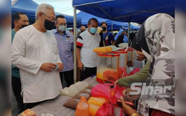 Noh (kiri) membuat lawatan dan membeli juadah berbuka puasa pada Majlis Iftar Bersama Peniaga di Tapak Bazar Ramadan Tanjong Karang pada Jumaat.