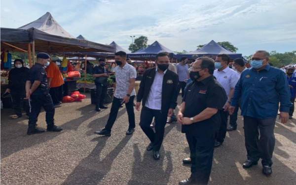 Ahmad (dua dari kanan) mengiringi Onn Hafiz (tiga dari kanan) ketika membuat lawatan di Pasar Tani Jalan Datin Halimah di sini, pada Sabtu.