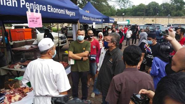 Datuk Seri Saifuddin meninjau gerai peniaga yang mengambil bahagian pada Jualan MyRakyat Sentuhan Kasih Aidilfitri Parlimen Indera Mahkota di perkarangan Wisma Belia di sini pada Sabtu.
