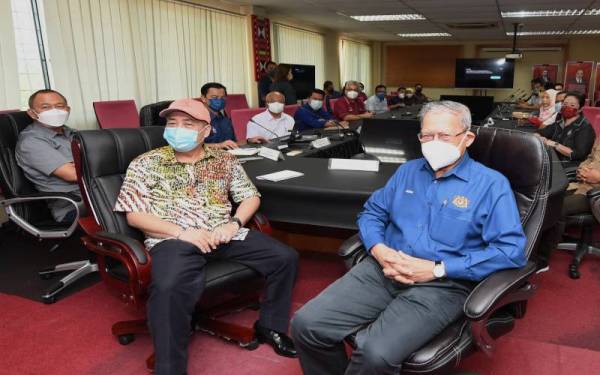 Hajiji bersama Mustapha ketika diberi taklimat mengenai pembangunan daerah Tuaran, pada Sabtu. Foto Bernama.
