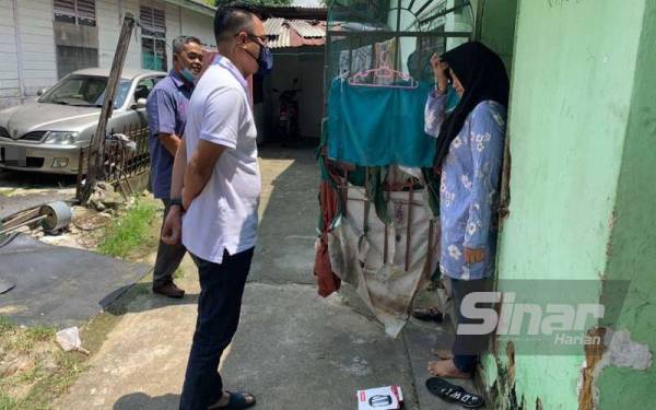 Mohd Hairi (kiri) ketika melawat dan mmenghulurkan sumbangan kepada Nur Rizan di rumahnya di Kampung Melayu Majidee, Johor Bahru pada Jumaat.