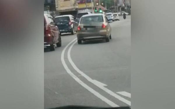 Tangkap layar video tular sebuah kereta memandu secara berbahaya memotong barisan di garisan berkembar di Kilometer 17, Jalan Beruas-Parit-Ipoh dekat pekan Parit pada Rabu.