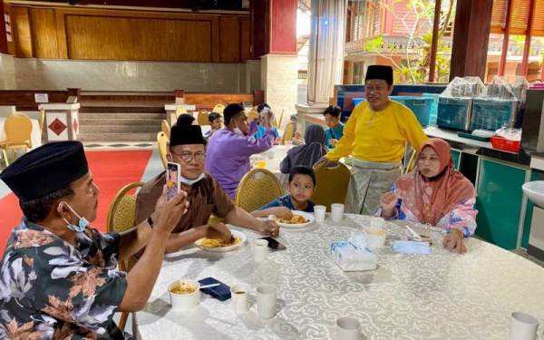 Ahmad (berdiri) melayan tetamu yang hadir pada Majlis Rumah Terbuka Ahli Parlimen Pontian di Benut pada Sabtu.