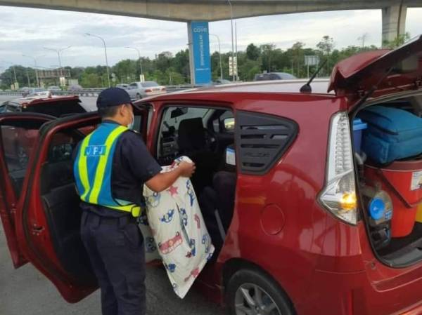 Anggota JPJ membantu mencari ular yang terdapat di dalam kereta seorang wanita yang berhenti di lorong kecemasan Kilometer 26.7 Lebuh Raya Utara-Selatan Hubungan Tengah (Elite) pada Ahad.