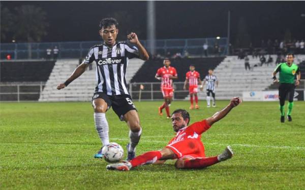 Pemain Terengganu FC II, Engku Muhammad Nur Shakir Engku Yacob (kiri) diasak pemain Kelantan FC, Khairul Helmi Johari (kanan) pada perlawanan Liga Premier di Stadium Sultan Ismail Nasiruddin Shah, pada Ahad. 