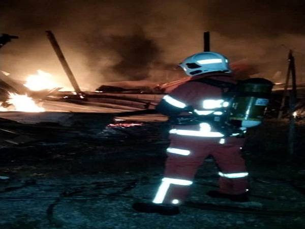 Anggota bomba memadamkan kebakaran di sebuah rumah di Jalan Parit Abas, Benut, Pontian, pada Isnin yang mengorbankan seorang lelaki warga emas.