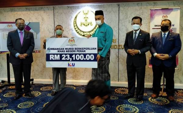 Saarani (dua dari kiri) menyerahkan sumbangan berjumlah RM23,100 kepada Badan Kebajikan Sektor Pembangunan Murid, JPN Perak kepada Pengarah Pendidikan negeri, Aznan Alias pada Isnin.