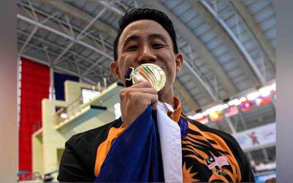 Atlet Terjun Negara, Ooi Tze Liang dengan pingat emas yang dimenangi beliau dalam acara 1M papan anjal individu Lelaki sempena Sukan SEA 2021 di Pusat Akuatik My Dinh pada Isnin. - Foto Bernama