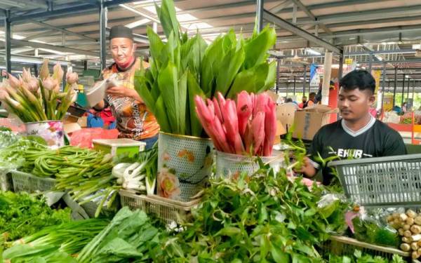 Roslan (kiri) tidak mahu mengambil risiko menjual sayur sawi bunga yang meningkat mendadak di Pasar Awam Bachang, Melaka pada Selasa.