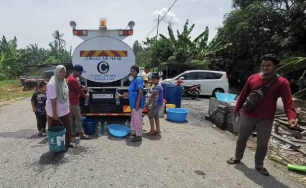 Penduduk di Mukim Kota Setia mengambil air yang dibekalkan LAP setelah mengalami gangguan air sejak seminggu lalu.- Foto ihsan pembaca 