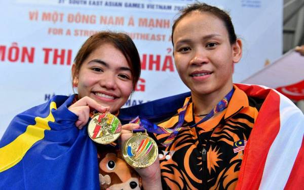 Pandelela dan Dhabitah bersama pingat emas yang dimenangi mereka pada acara akhir 10 Meter platform seirama wanita pada Sukan SEA ke-31 di My Dinh Water Sports Stadium hari ini. Foto Bernama