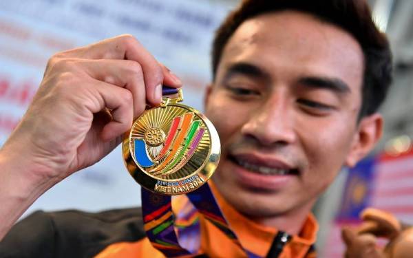 Muhammad Syafiq bersama pingat emas yang dimenanginya pada acara akhir 3 meter papan anjal lelaki pada Sukan SEA ke-31 di My Dinh Water Sports Stadium pada Rabu. - Foto Bernama