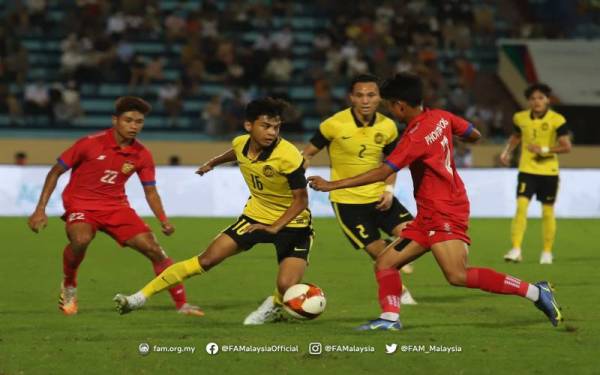 Pemain skuad B-23 negara, Muhammad Syahir Bashah mengawal bola walaupun cuba dihalang pemain pertahanan Laos di Stadium Thien Ruong pada malam Rabu. - Foto FB FAM