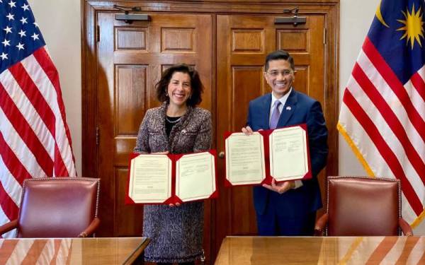 Gina M Raimondo (kiri) dan Mohamed Azmin memeterai Memorandum Kerjasama (MOC) AS-Malaysia mengenai daya tahan rantaian bekalan semikonduktor.