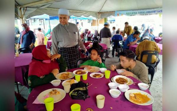 Razman (berdiri) melayani tetamu yang hadir pada Majlis Rumah Terbuka Hari Raya Aidilfitri Ahli Dewan Undangan Negeri (ADUN) Semanggol di Taman Serai Permai, di sini pada Khamis.