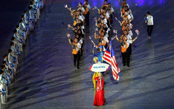 Atlet terjun wanita negara, Nur Dhabitah Sabri diberi penghormatan membawa Jalur Gemilang ketika perarakan masuk kontinjen Malaysia yang diketuai Chef-de-misson (CDM) ke Sukan SEA Hanoi 2021, Datuk Seri Nur Azmi Ahmad pada upacara pembukaan rasmi temasya sukan tersebut di Stadium Nasional My Dinh, Hanoi. - Foto Bernama