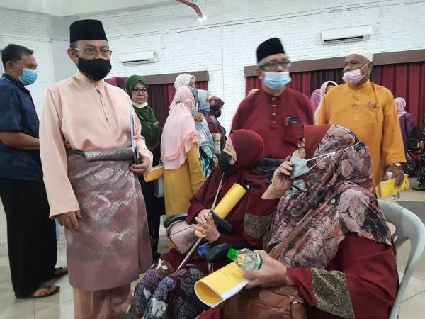 Abdul Fattah (kiri) beramah mesra dengan peserta pada Mesyuarat Agong Koperasi Pembangunan Daerah Kuantan di Kompleks Dagangan Mahkota, Jalan Sultan Ahmad Shah pada Sabtu.